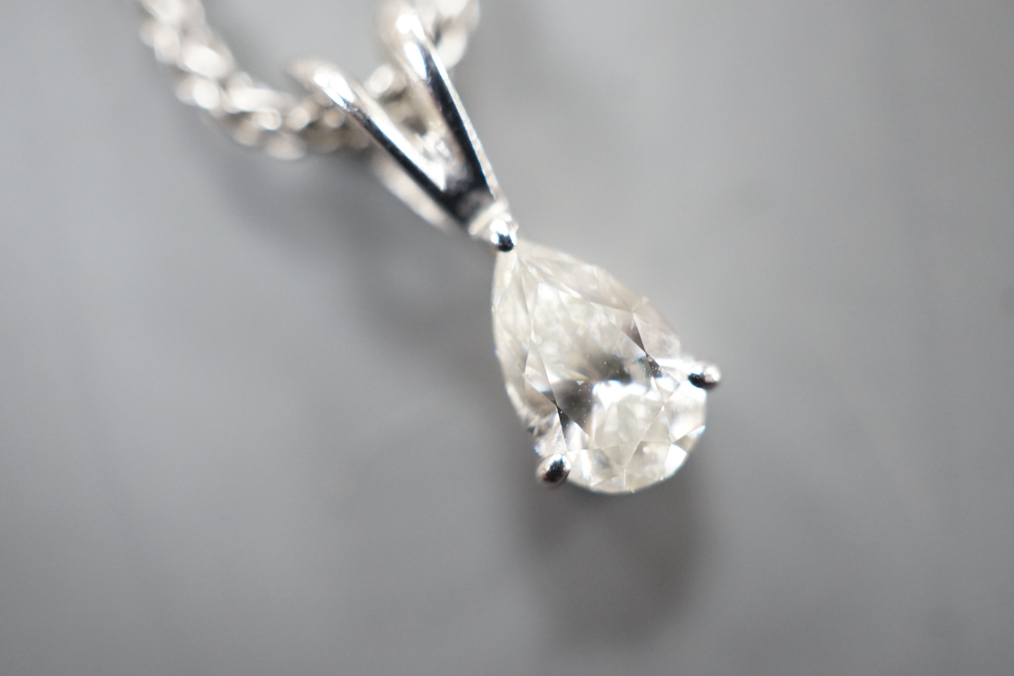 A modern white metal and pear cut diamond set pendant, 13mm, on an 18ct white gold chain, 39cm, gross weight 4.5 grams.